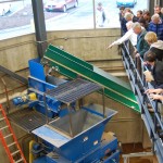 Tom McGinn points to wood chips carried along the conveyer belt.