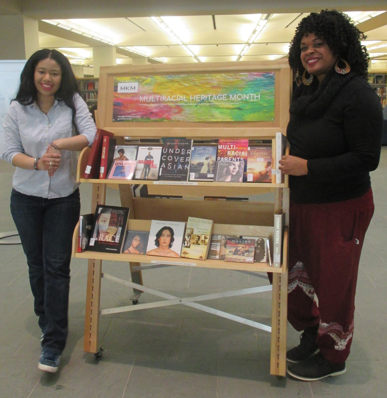 two women pose with a book cart