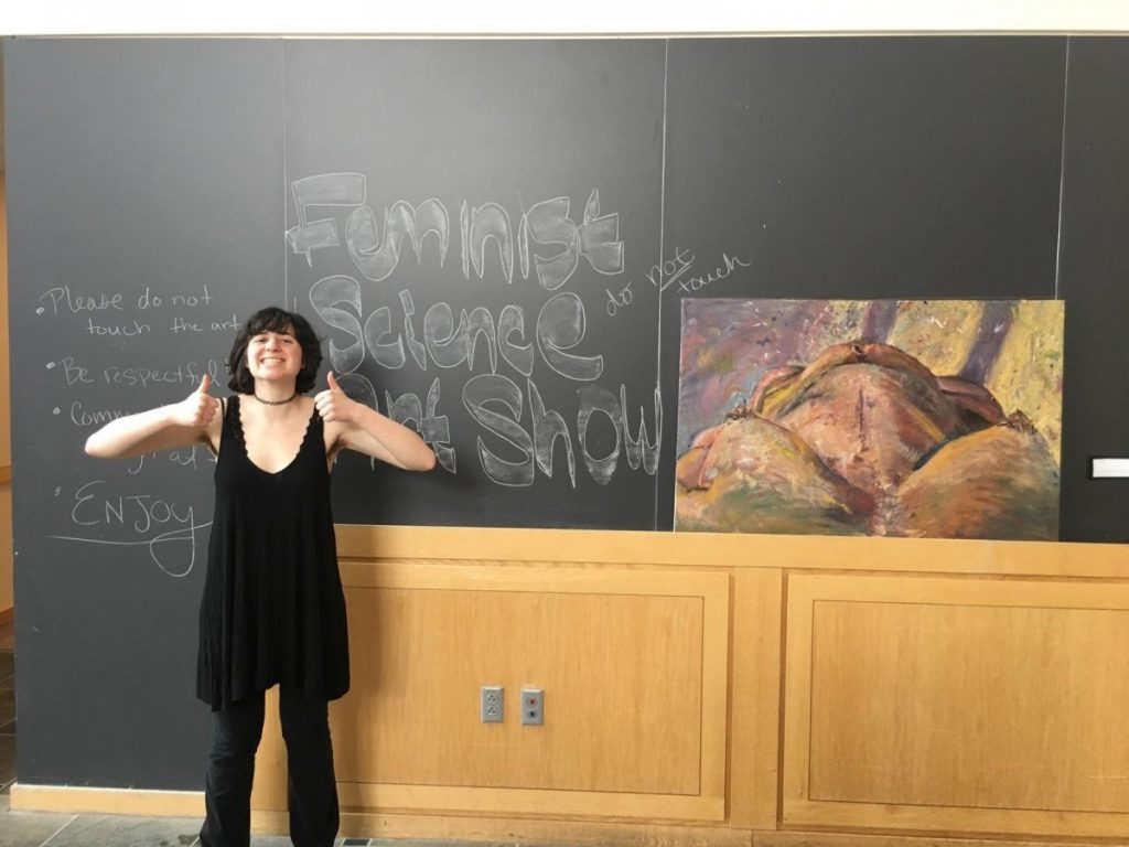 a woman posing in front of a blackboard