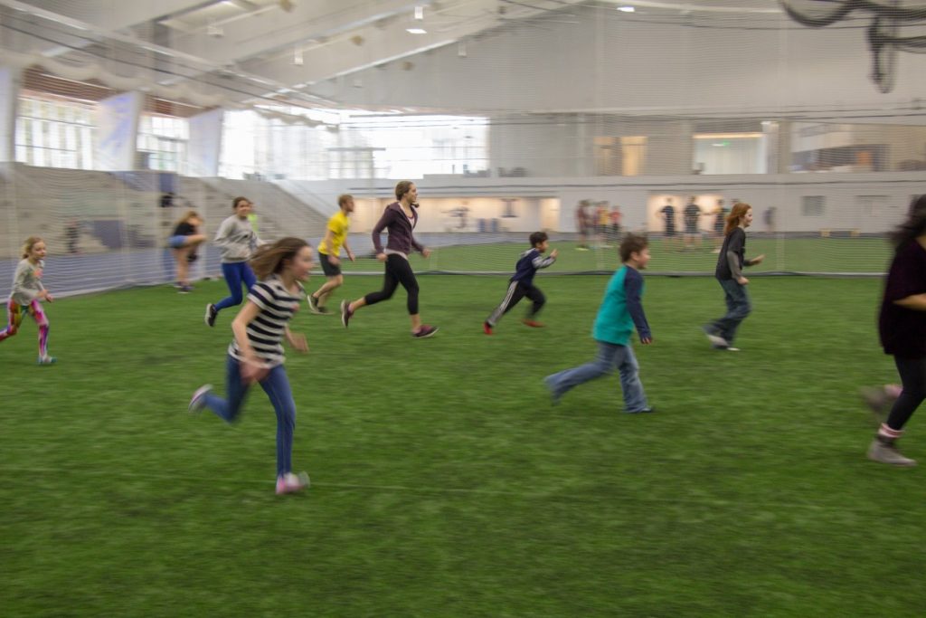 Kids playing soccer indoors