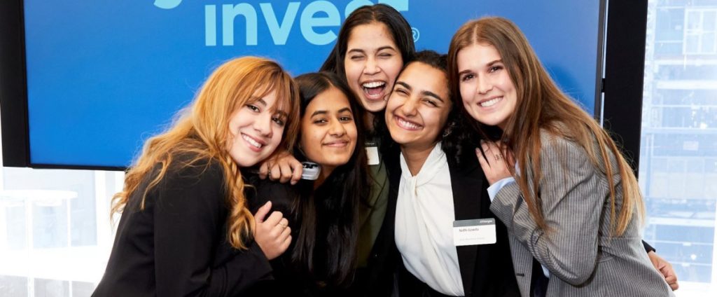 Photo of 5 diverse, female-identifying college students dressed in business attire.