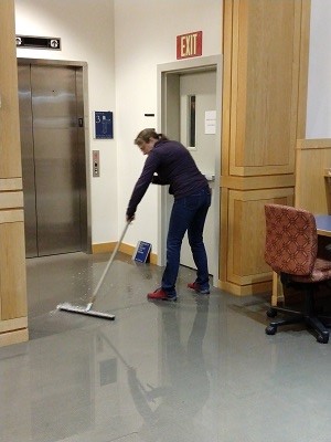 Science Data Librarian Wendy Shook mops the floor in Armstrong Library, Middlebury College